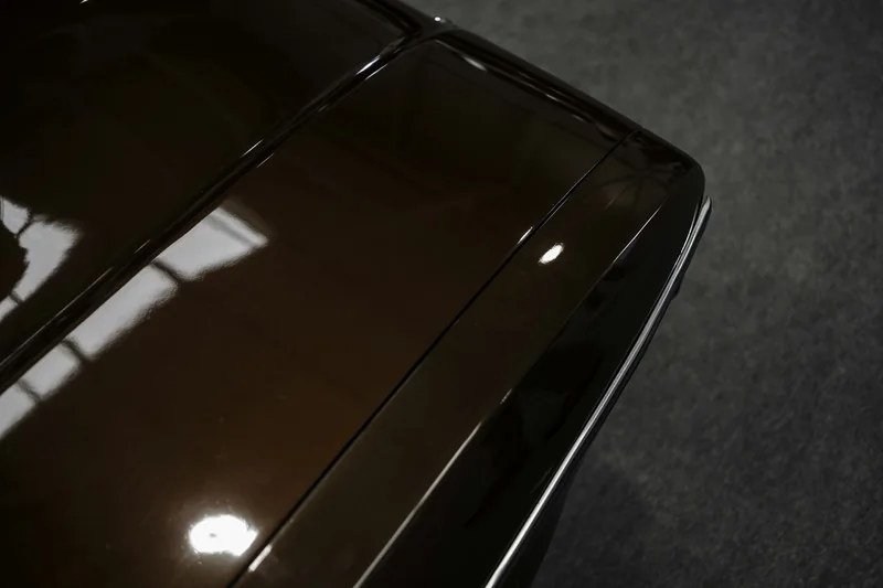 Glänzende dunkle Motorhaube mit Lichtreflex
